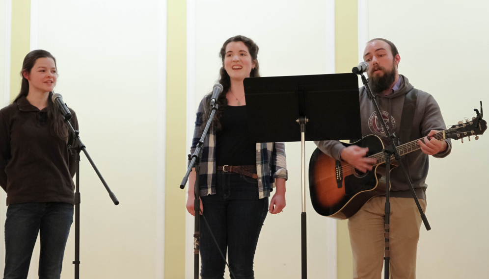 Two singers and a guitarist perform