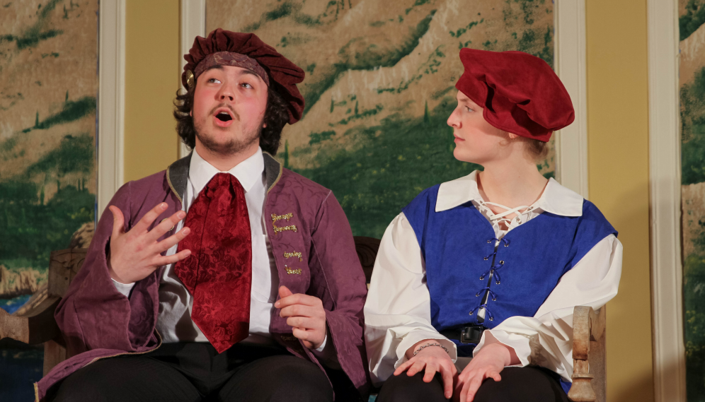 Seated on a bench, the man in the cravat holds forth to the girl in the puffy red hat