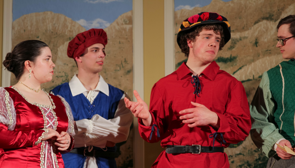 Lady Olivia (in red), the man in red, and Malvolio in cozy-looking forest green peeping in from the right side of the frame