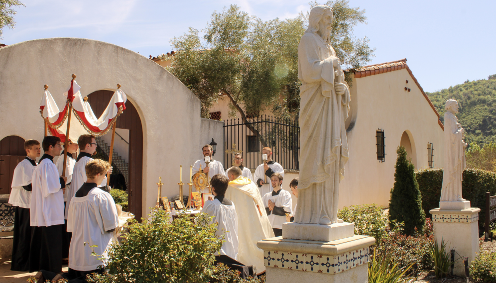 The monstrance is set up at the makeshift altar and Fr. Marczeski kneels before it