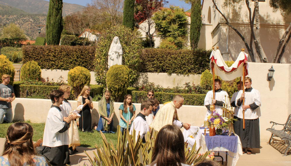 Another view of the monstrance set up on the outdoor altar, with the congregation kneeling around it