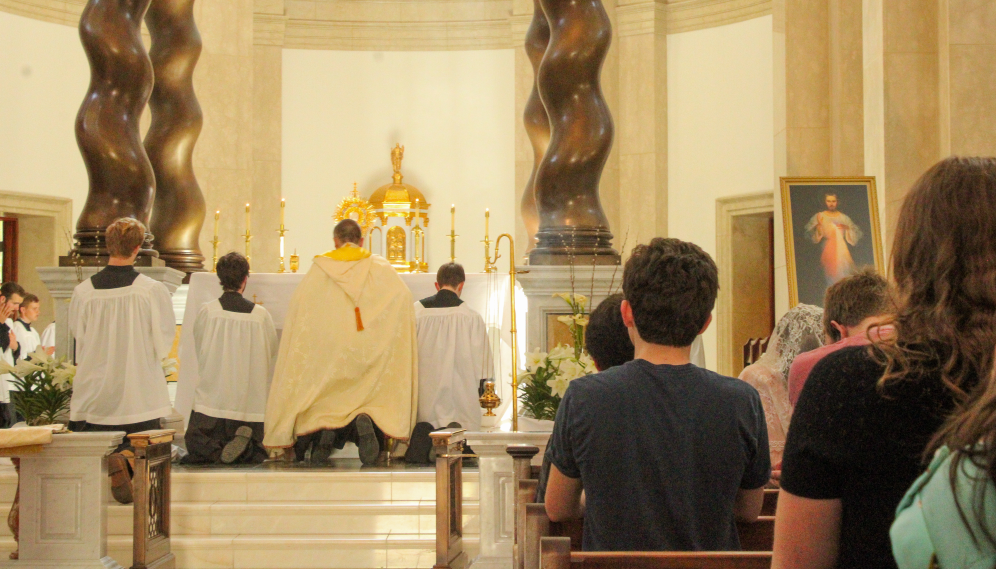 The priest and servers kneeling at the Chapel altar
