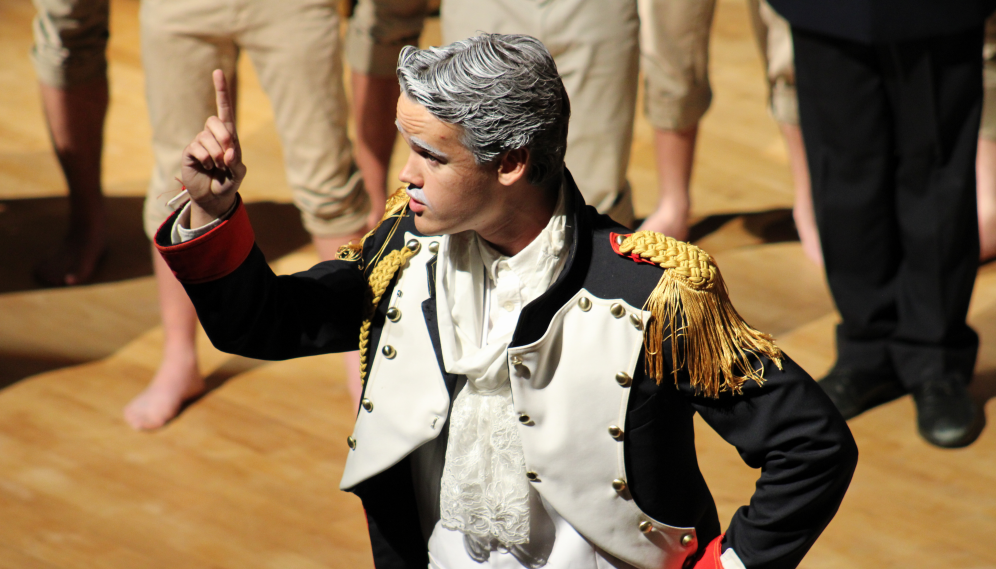 A commander with grey hair and mustache