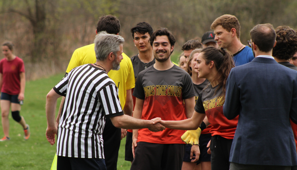 Dr. Gardner (the ref) shakes hands with TMC students