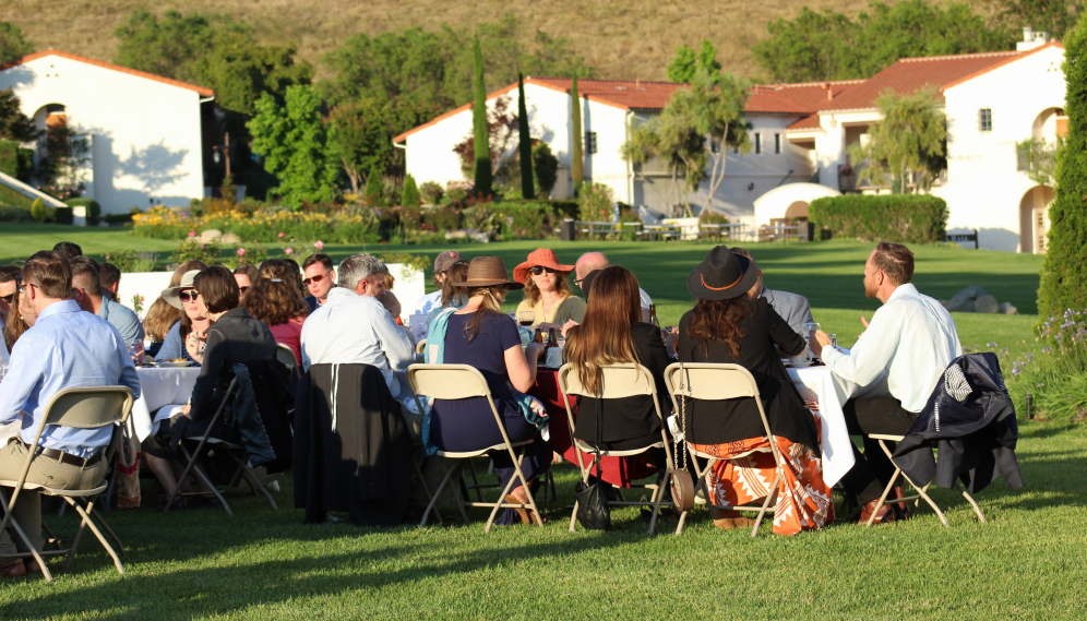 The attendees eat at long tables