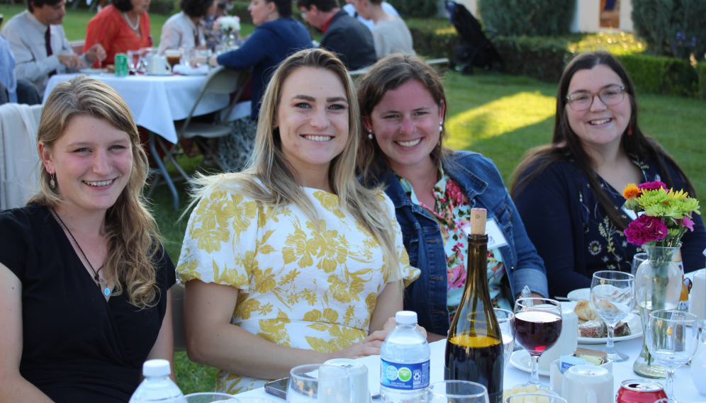 Four pose together at the table