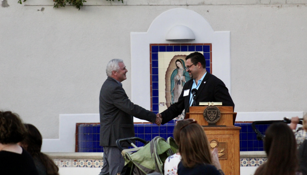 The alumnus shakes hands with President O'Reilly