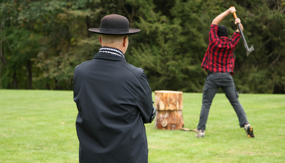 Fr. Viego watches someone split a log