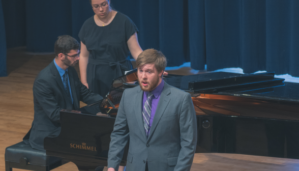 A student sings while accompanied by another at the piano