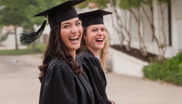 Two graduates laughing