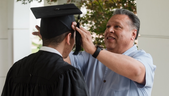 A proud father places the cap on his son's head