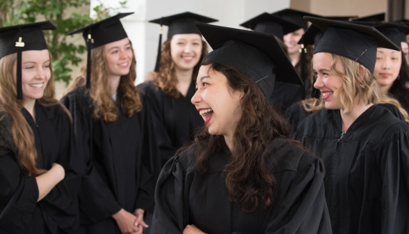 Laughing graduates chatting in a group