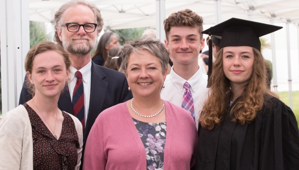 Three generations of family pose together with their graduate