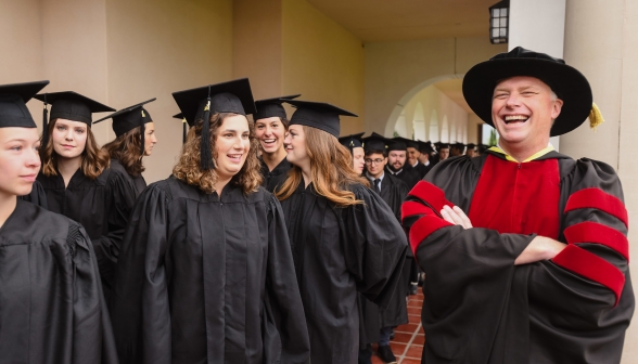 Dr. Seeley laughs with the line of passing graduates