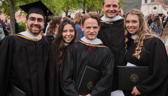 Five students in graduating robes
