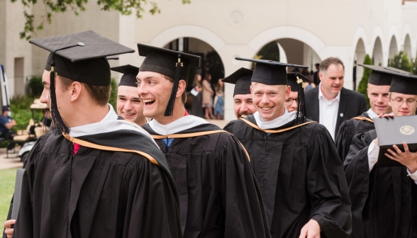Laughing graduates in line
