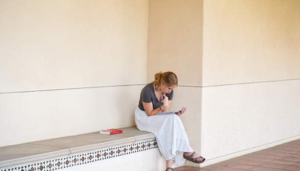 Student reads by academic quadrangle