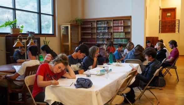 Students at folding tables near the back of the library