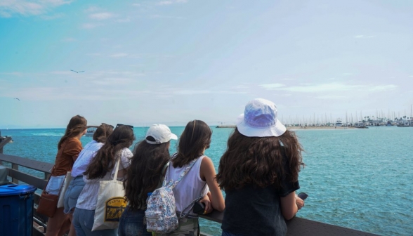 Six students at the railing, watching the seagulls