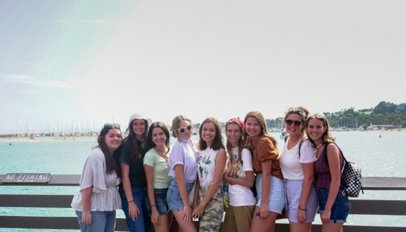 Nine girls pose afront the bay