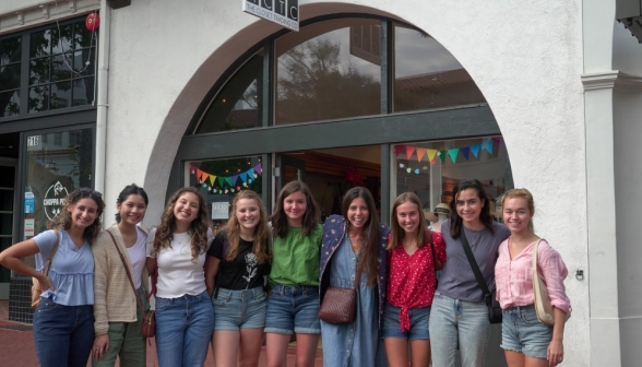 Nine girls afront the Closet Trading Co's arched window