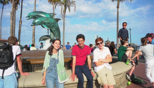 Three students pose at the Dolphin Fountain
