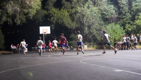 Students run toward one end of the court, where the action is