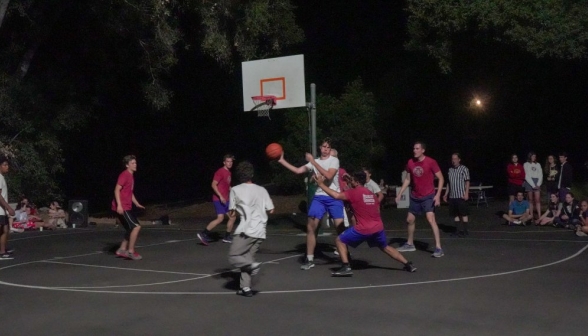 A student protects the ball from a prefect, while another student lines himself up to receive a pass