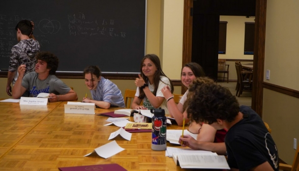 Studying students. One gives the "thumbs-up" to the camera