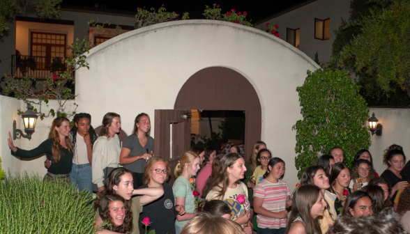 The women, watching the singing with happy surprise