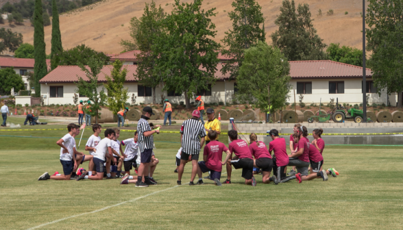 The students kneel in prayer before the game