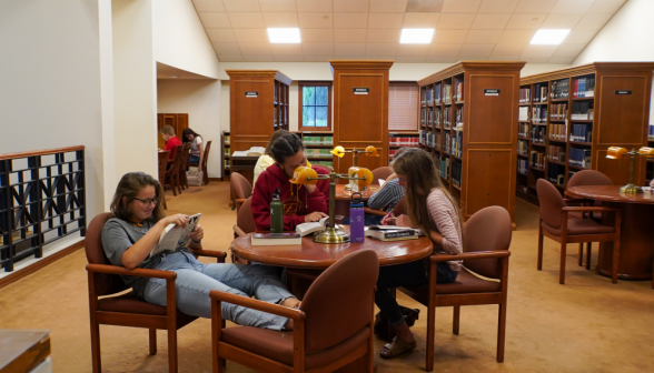 Three at a table on the right side of the library