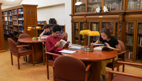 Two at a study table, poring over their books