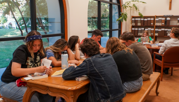 Students fill the long side table and small niche table in the library's left wing