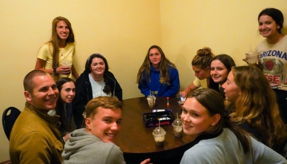 Students crowd around a game of Taboo