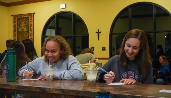 Students at the counter write and enjoy coffee