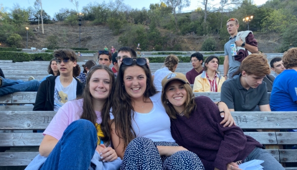 Three students pose for a photo in the benches