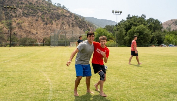 Thumbs up from a summer program student in a knee brace, supported by a prefect