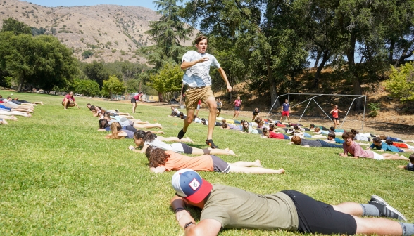 Another student in mid-jump as he runs down the line