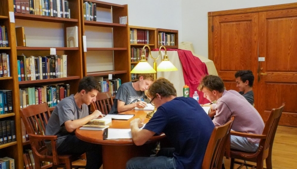 Five study intently at another table