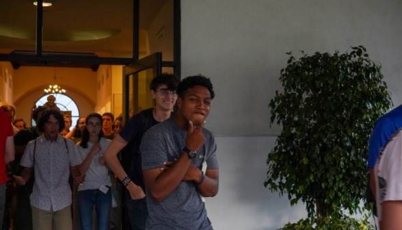 A students make a "thoughtful" pose for the camera as he comes out of the library