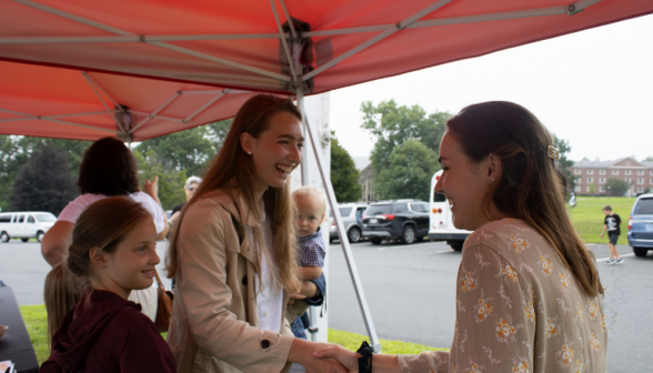 Mary O'Reilly, prefect, greets a family at the registration table