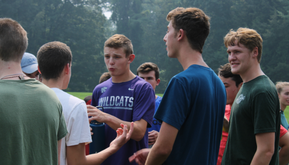 A group of students discussing the games on the field