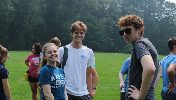 Three students smile for the camera