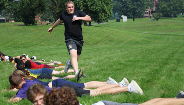 A student completes his run down the row of fellow students