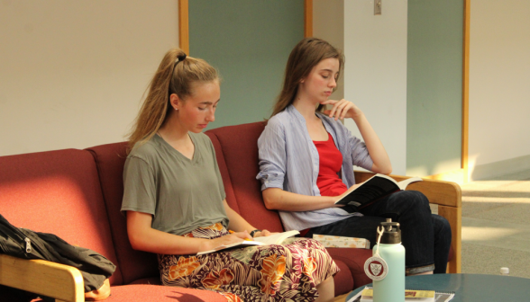 Two students reading on a long couch