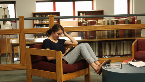 A student in an armchair, reading