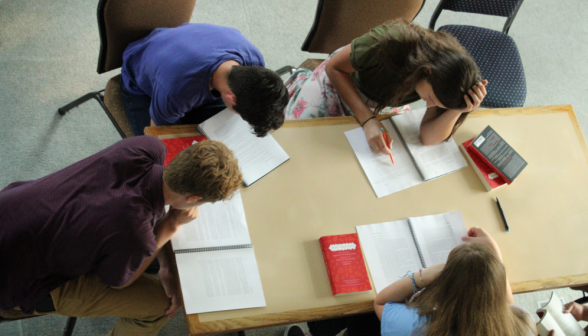 Overhead view: four at work at a rectangle table