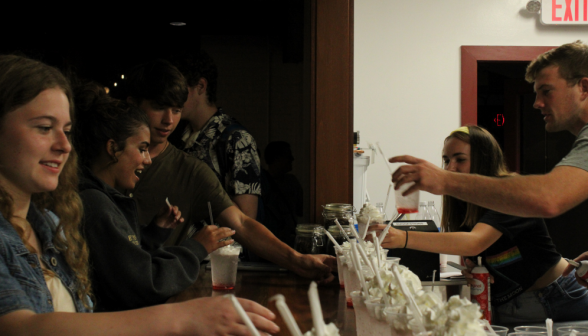 Prefects passing Italian sodas while the students take them on the other side of the counters