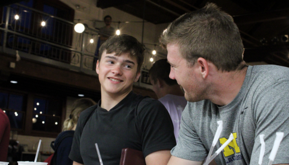 David Carey chats with a student at the counter